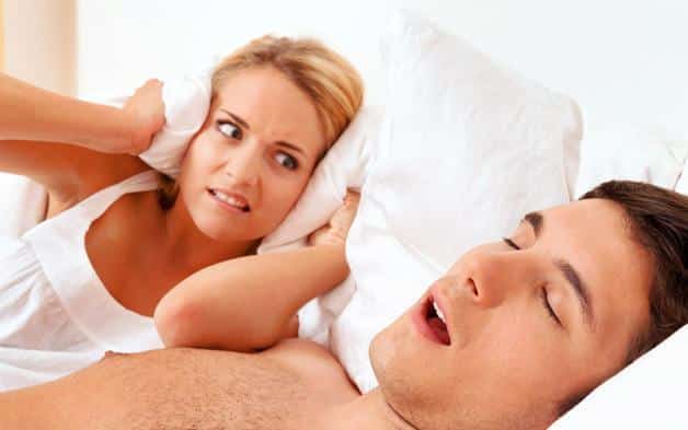 man snoring while woman is looking at her